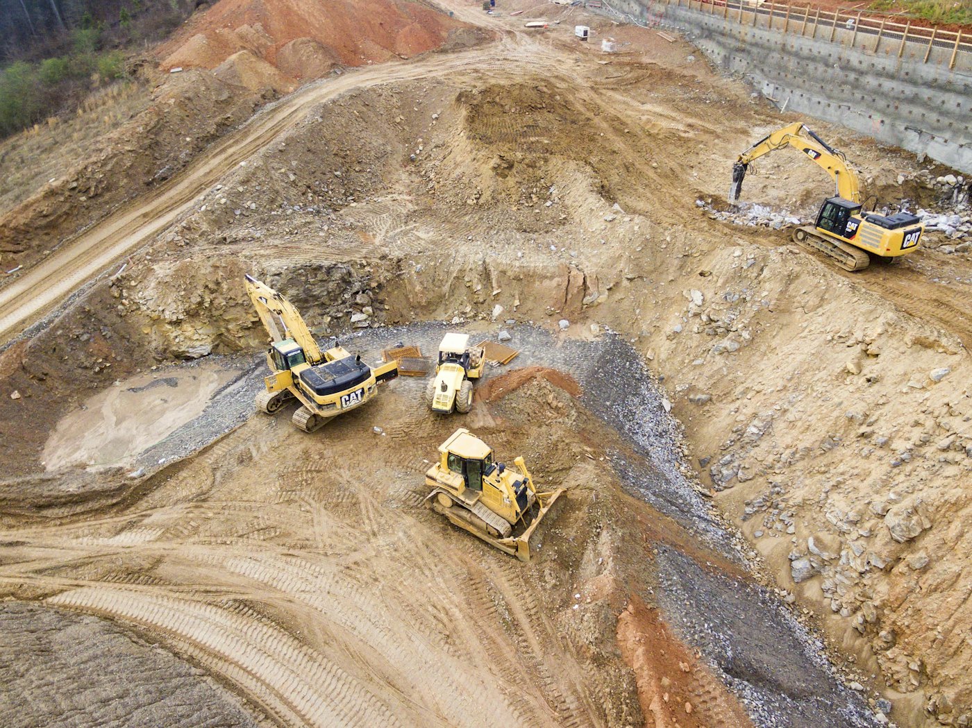 Excavators and dozer cutting a site